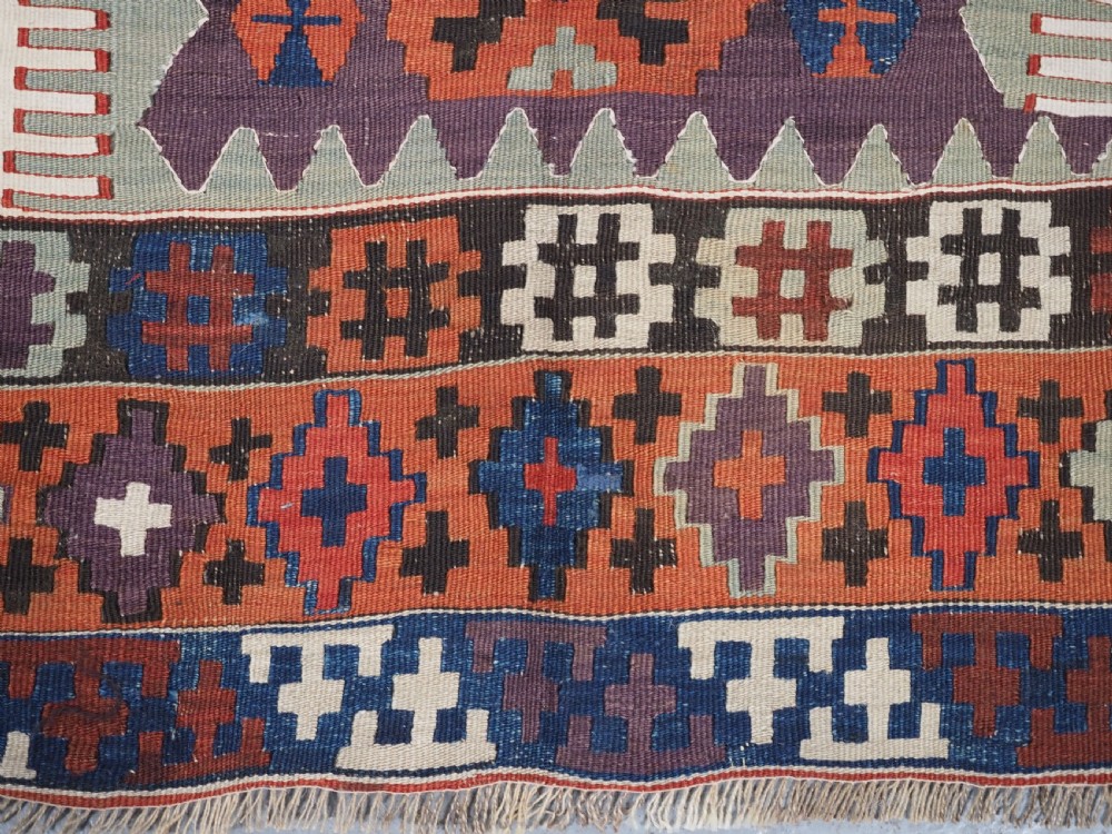 An antique handwoven Turkish Obruk kilim rug featuring a central mihrab niche motif surrounded by geometric borders in terracotta red, dark blue, green, and dark brown. View XIII