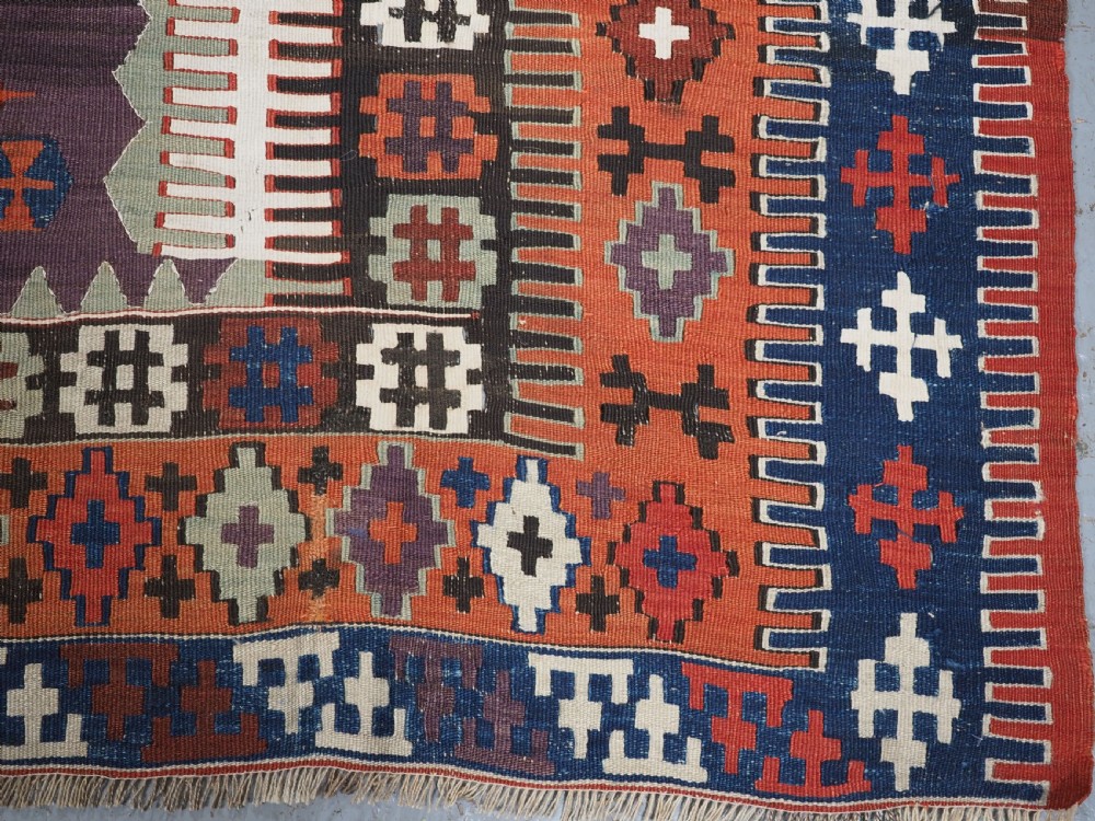 An antique handwoven Turkish Obruk kilim rug featuring a central mihrab niche motif surrounded by geometric borders in terracotta red, dark blue, green, and dark brown. View XIV