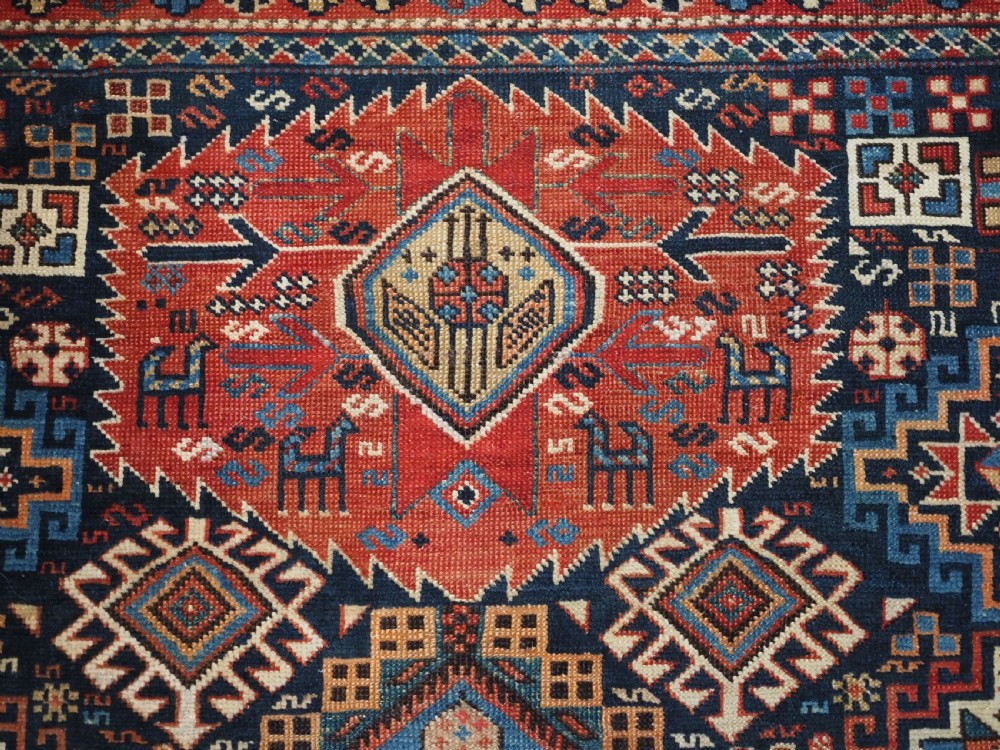 An antique late 19th-century Caucasian Shirvan hand-knotted wool rug featuring geometric diamond medallions, multi-coloured tribal motifs, and a distinct Kufic border. View VIII