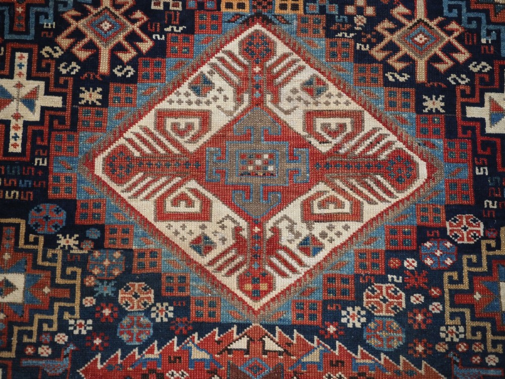 An antique late 19th-century Caucasian Shirvan hand-knotted wool rug featuring geometric diamond medallions, multi-coloured tribal motifs, and a distinct Kufic border. View XIII