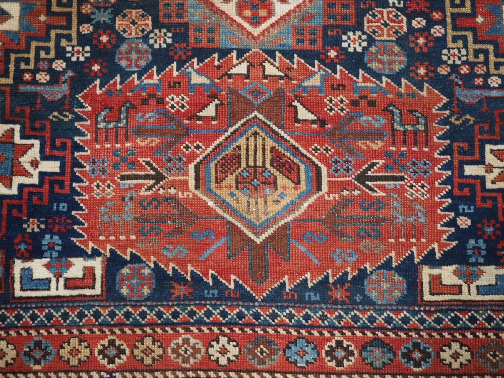 An antique late 19th-century Caucasian Shirvan hand-knotted wool rug featuring geometric diamond medallions, multi-coloured tribal motifs, and a distinct Kufic border. View XIV