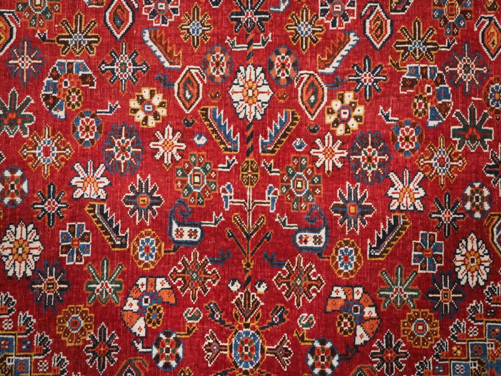 An antique hand-knotted wool Qashqai rug featuring a central stepped medallion surrounded by intricate geometric motifs in shades of terracotta red, indigo blue, and ivory. View XI