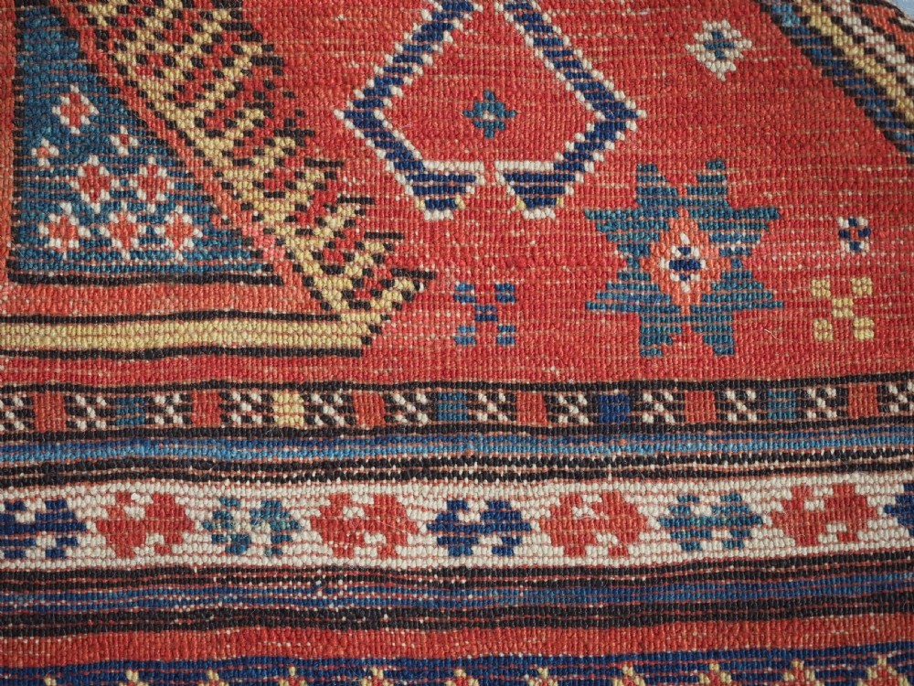 An antique Caucasian Sewan Kazak wool rug featuring a red keyhole medallion set against a navy blue and cream background with geometric borders. View XIX