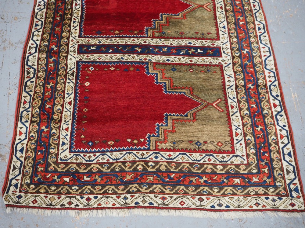 An antique Turkish Sivas Saf hand-knotted wool rug featuring three distinct red stepped prayer niches framed by olive green panels and multi-layered geometric borders. View V