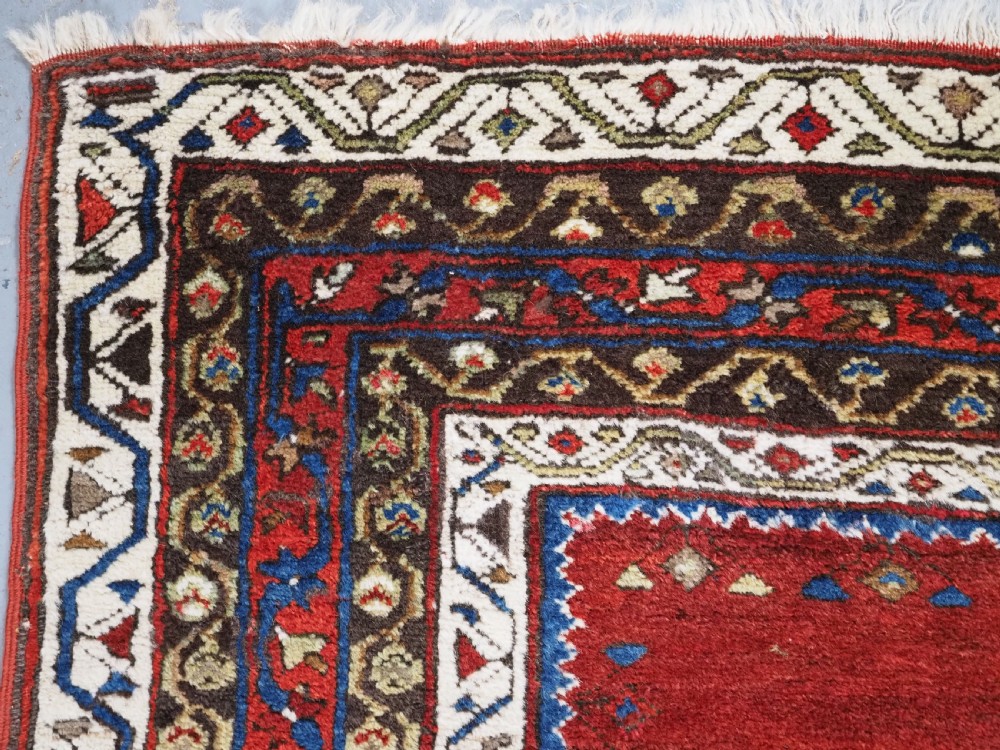 An antique Turkish Sivas Saf hand-knotted wool rug featuring three distinct red stepped prayer niches framed by olive green panels and multi-layered geometric borders. View VI