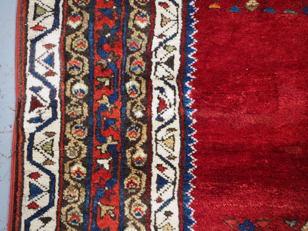An antique Turkish Sivas Saf hand-knotted wool rug featuring three distinct red stepped prayer niches framed by olive green panels and multi-layered geometric borders. View VII