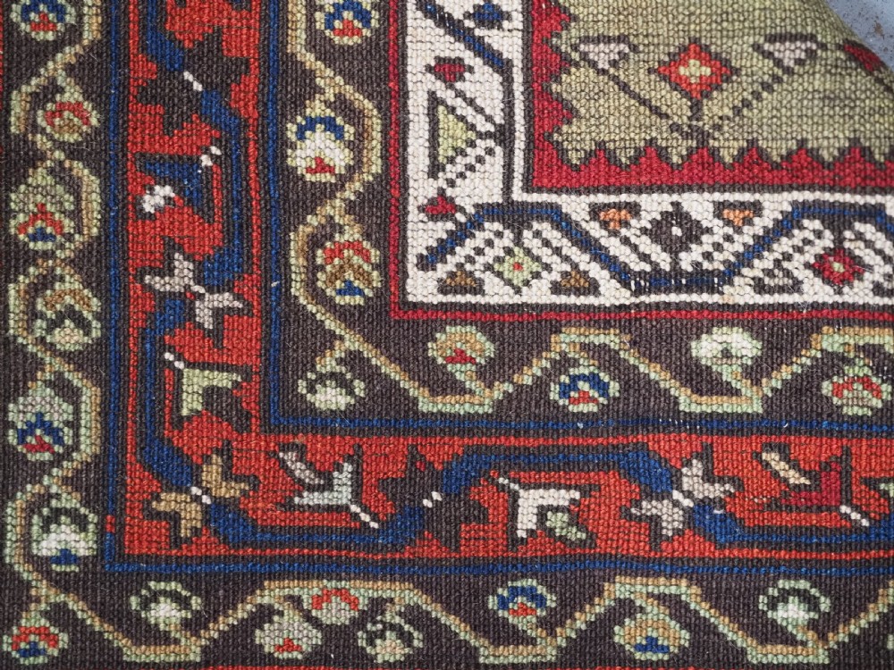 An antique Turkish Sivas Saf hand-knotted wool rug featuring three distinct red stepped prayer niches framed by olive green panels and multi-layered geometric borders. View VIII