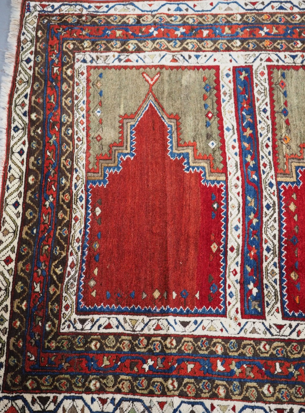 An antique Turkish Sivas Saf hand-knotted wool rug featuring three distinct red stepped prayer niches framed by olive green panels and multi-layered geometric borders. View XI
