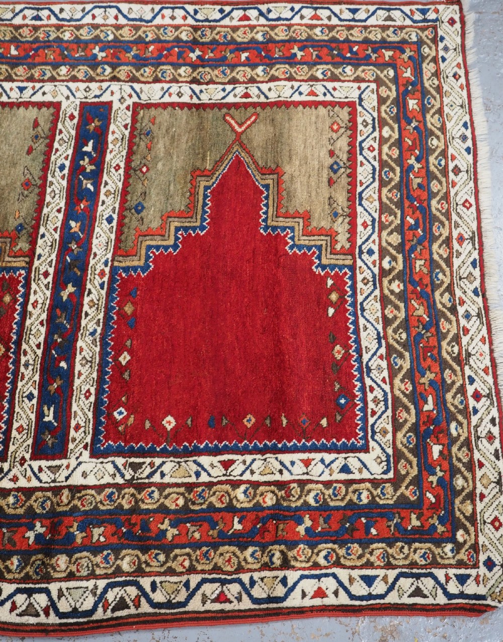 An antique Turkish Sivas Saf hand-knotted wool rug featuring three distinct red stepped prayer niches framed by olive green panels and multi-layered geometric borders. View XIII