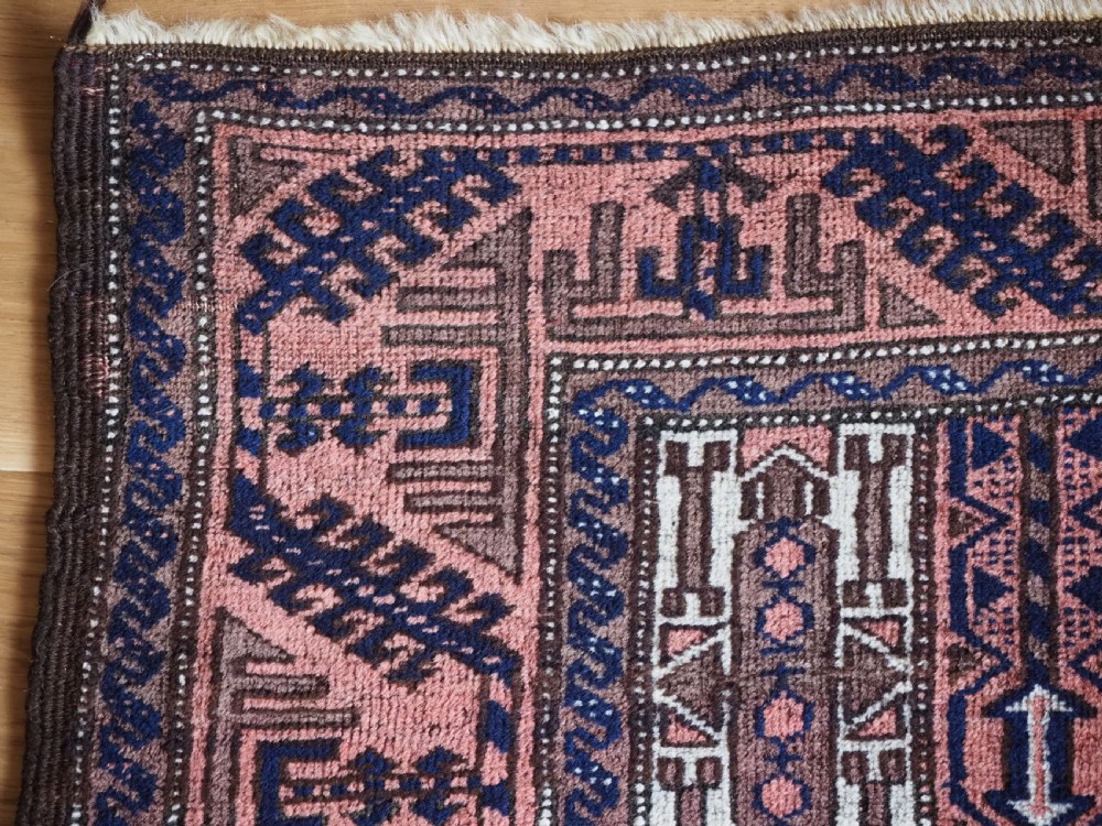 An antique hand-knotted Baluch wool rug featuring vertical stripe patterns in terracotta, navy blue, and white tones. View VI