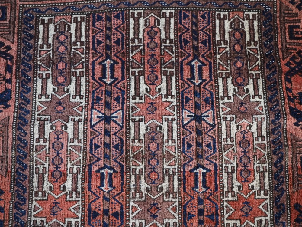An antique hand-knotted Baluch wool rug featuring vertical stripe patterns in terracotta, navy blue, and white tones. View VIII