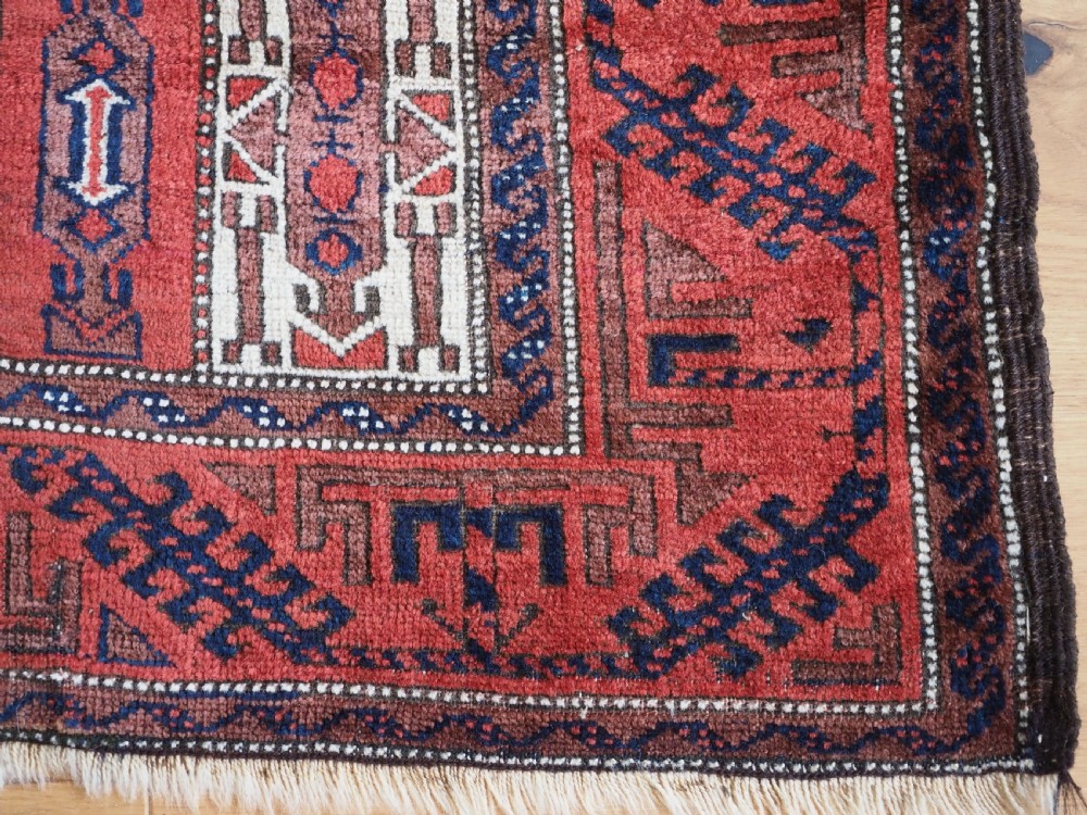 An antique hand-knotted Baluch wool rug featuring vertical stripe patterns in terracotta, navy blue, and white tones. View XI