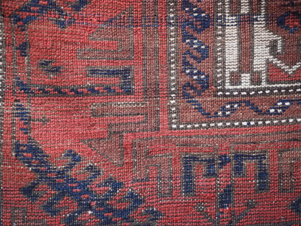 An antique hand-knotted Baluch wool rug featuring vertical stripe patterns in terracotta, navy blue, and white tones. View XII