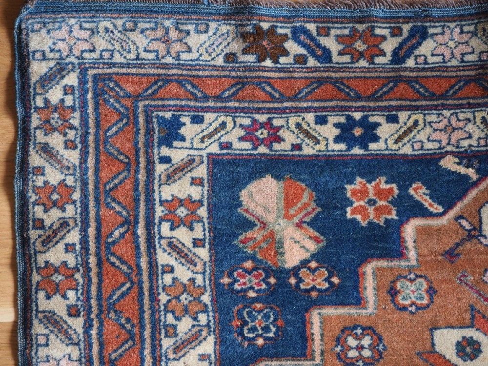 An antique Caucasian Derbent hand-knotted wool rug featuring three stepped medallions on a deep blue field with geometric borders. View VI