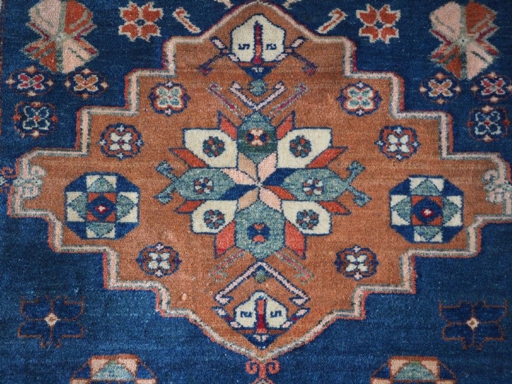 An antique Caucasian Derbent hand-knotted wool rug featuring three stepped medallions on a deep blue field with geometric borders. View VIII