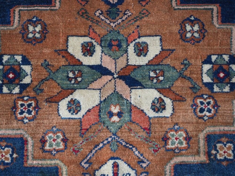 An antique Caucasian Derbent hand-knotted wool rug featuring three stepped medallions on a deep blue field with geometric borders. View XI