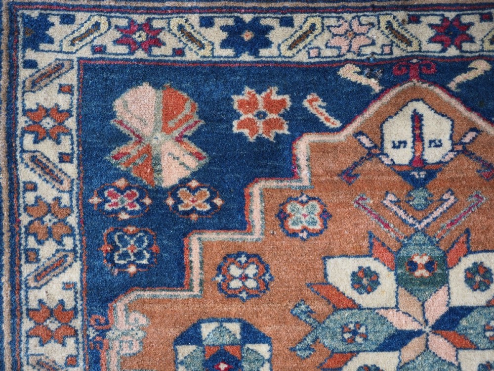 An antique Caucasian Derbent hand-knotted wool rug featuring three stepped medallions on a deep blue field with geometric borders. View XII