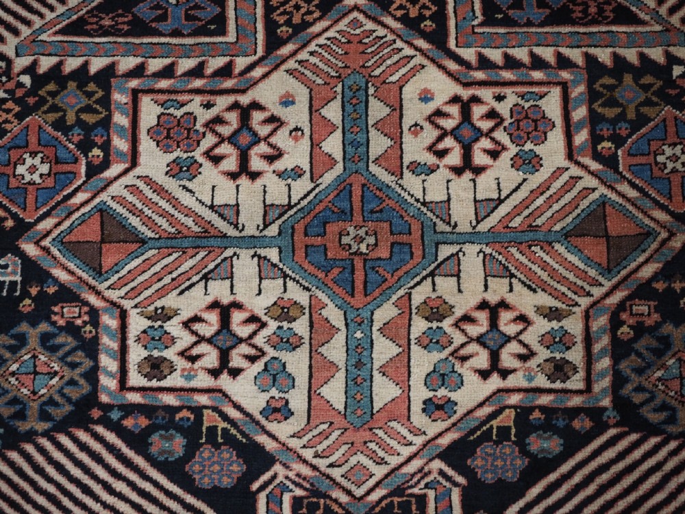 An antique Caucasian Akstafa wool rug runner featuring geometric star medallions and stylised peacock motifs on a dark navy field with a decorative border. View XI
