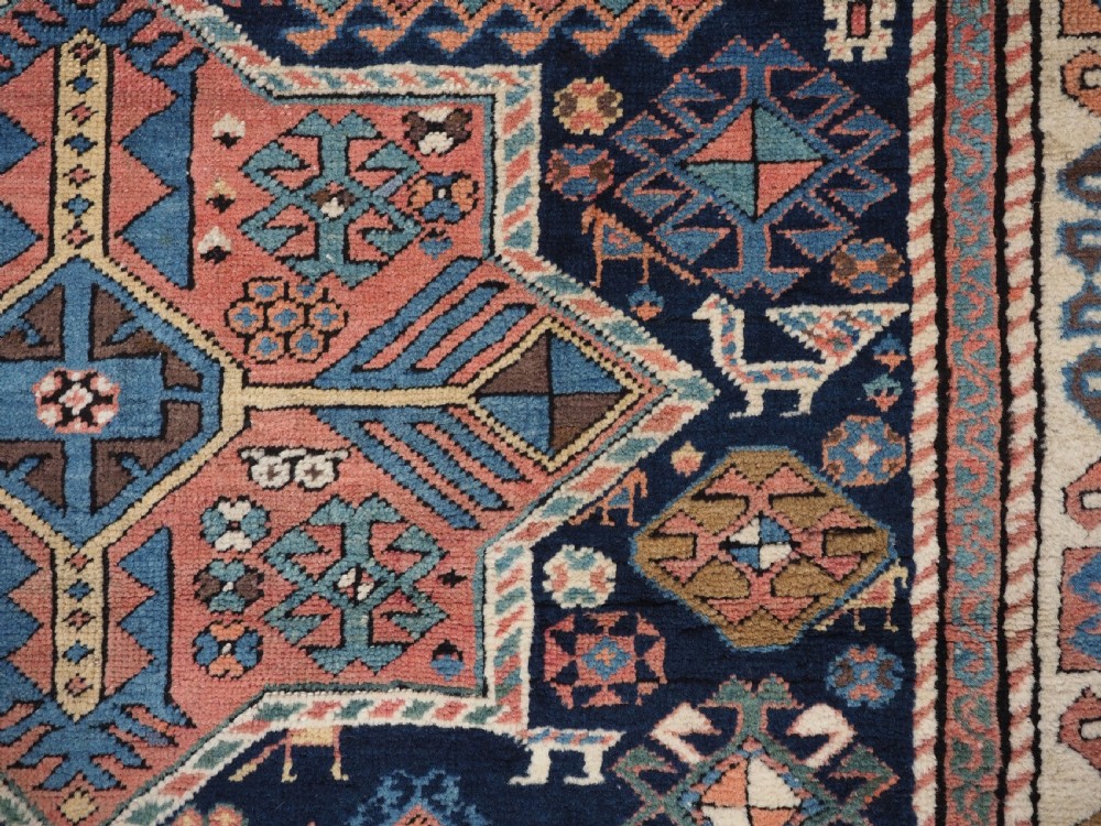 An antique Caucasian Akstafa wool rug runner featuring geometric star medallions and stylised peacock motifs on a dark navy field with a decorative border. View XIII