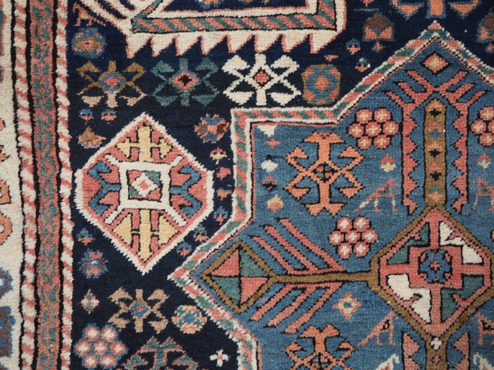 An antique Caucasian Akstafa wool rug runner featuring geometric star medallions and stylised peacock motifs on a dark navy field with a decorative border. View XIV