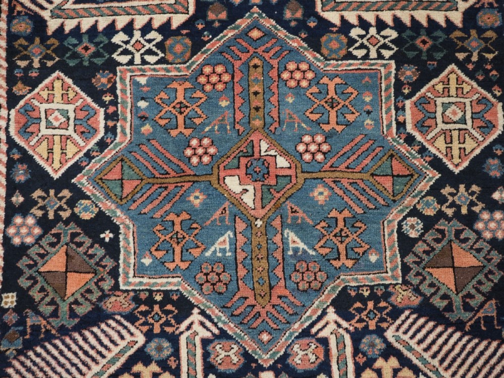 An antique Caucasian Akstafa wool rug runner featuring geometric star medallions and stylised peacock motifs on a dark navy field with a decorative border. View XV