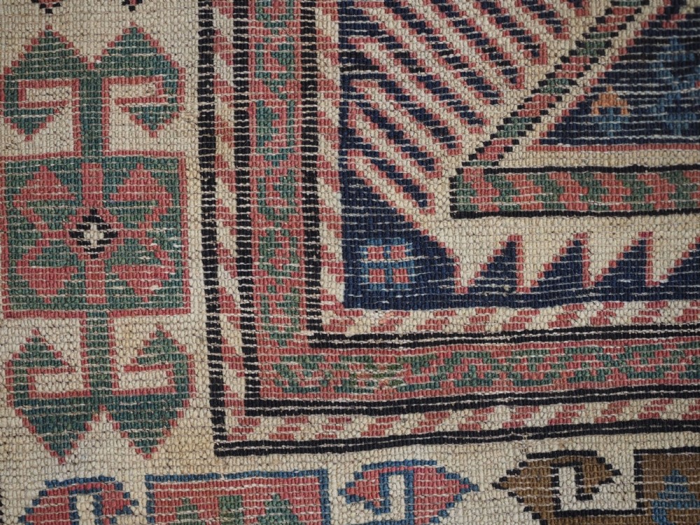 An antique Caucasian Akstafa wool rug runner featuring geometric star medallions and stylised peacock motifs on a dark navy field with a decorative border. View XVIII