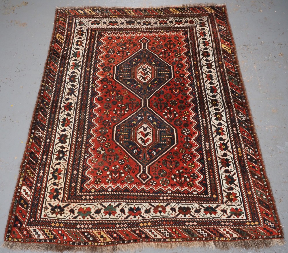 ANTIQUE SHIRAZ RUG WITH LINKED MEDALLION DESIGN, CIRCA 1920.