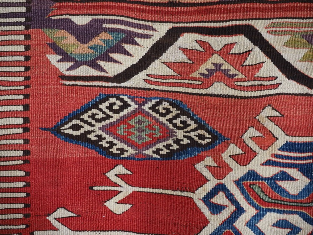 A long hand-woven Turkish Mut kilim rug featuring bold red, navy, brown, and cream geometric motifs arranged in horizontal bands. View V