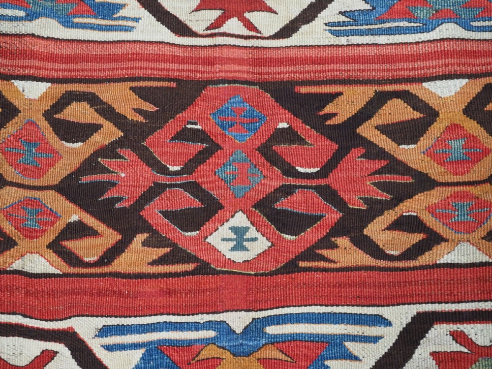 A long hand-woven Turkish Mut kilim rug featuring bold red, navy, brown, and cream geometric motifs arranged in horizontal bands. View VIII