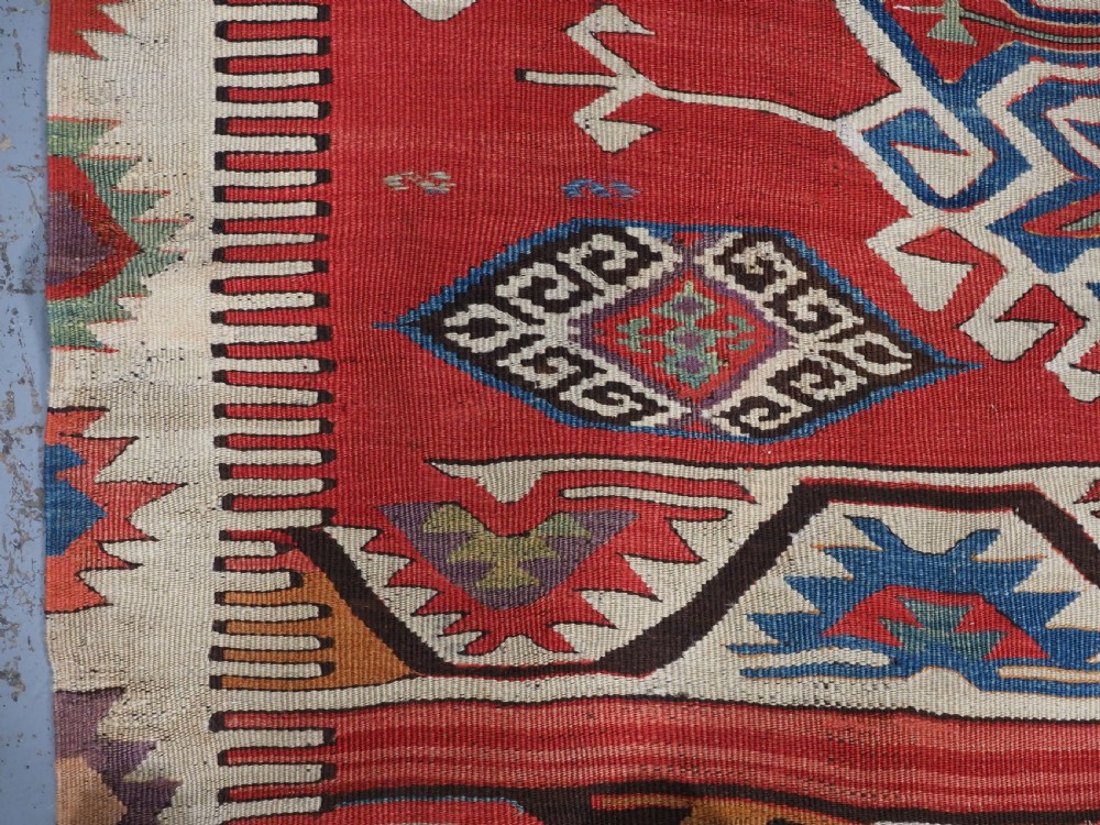 A long hand-woven Turkish Mut kilim rug featuring bold red, navy, brown, and cream geometric motifs arranged in horizontal bands. View XIII