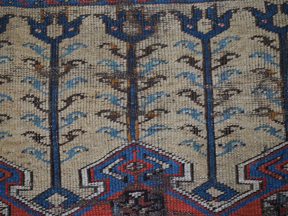 An antique hand-knotted Turkish Ladik prayer rug featuring a central red arched mihrab niche, blue spandrels, stylized floral panels, and a patterned multi-tiered border. View VI