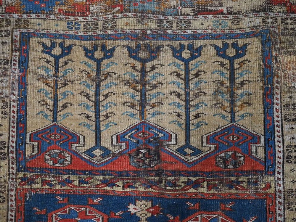An antique hand-knotted Turkish Ladik prayer rug featuring a central red arched mihrab niche, blue spandrels, stylized floral panels, and a patterned multi-tiered border. View XI