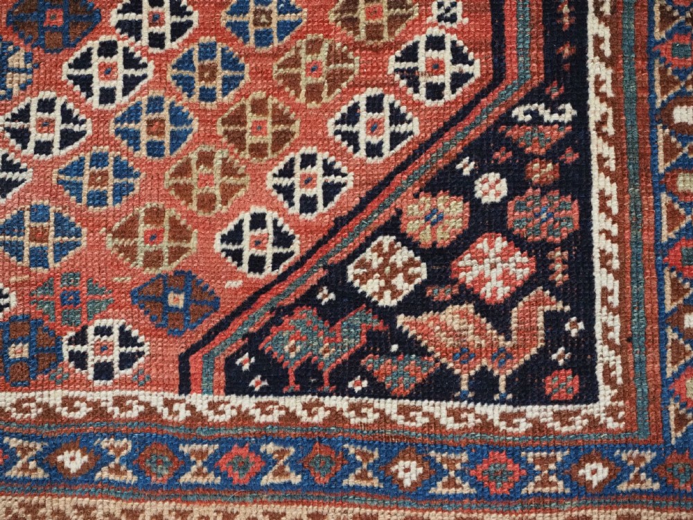 An antique Qashqai hand-knotted wool rug featuring a red and navy diamond lattice pattern with multi-band geometric borders. View XIV