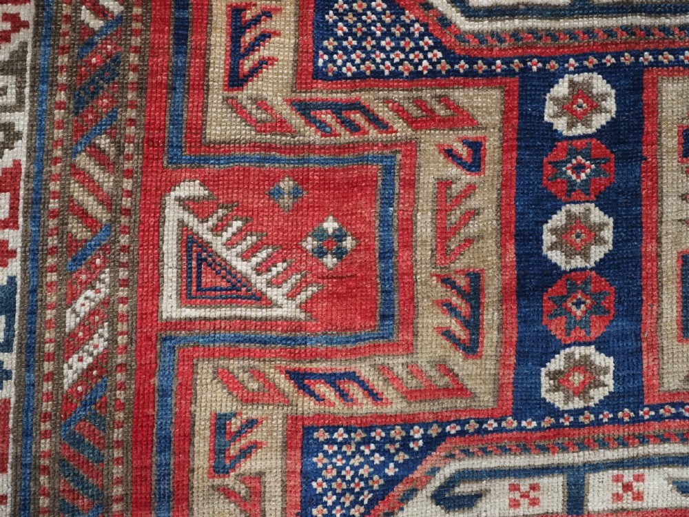 An antique Caucasian Shirvan long wool runner rug featuring terracotta red, navy blue, and beige octagonal geometric medallions within patterned borders. View XI