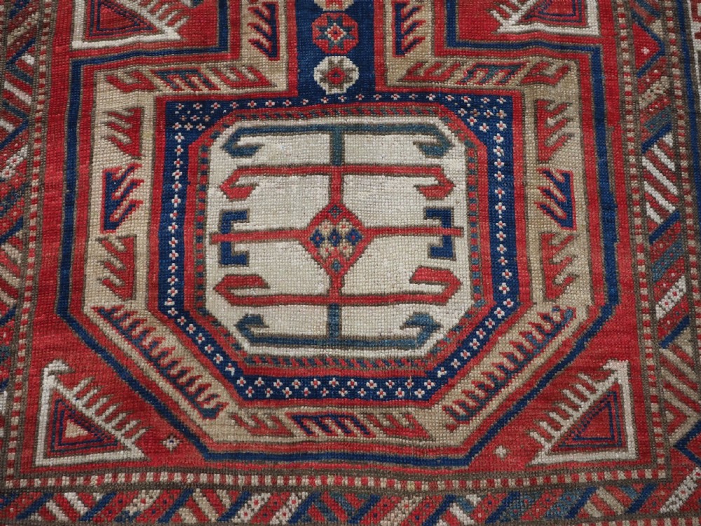 An antique Caucasian Shirvan long wool runner rug featuring terracotta red, navy blue, and beige octagonal geometric medallions within patterned borders. View XIII