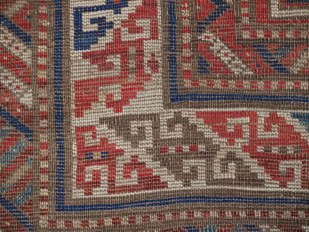 An antique Caucasian Shirvan long wool runner rug featuring terracotta red, navy blue, and beige octagonal geometric medallions within patterned borders. View XV