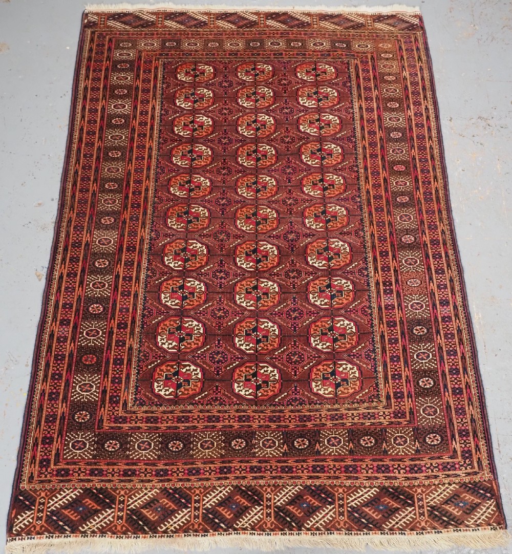 ANTIQUE TEKKE TURKMEN RUG, COCHINEAL DYE HIGHLIGHTS, CIRCA 1900.