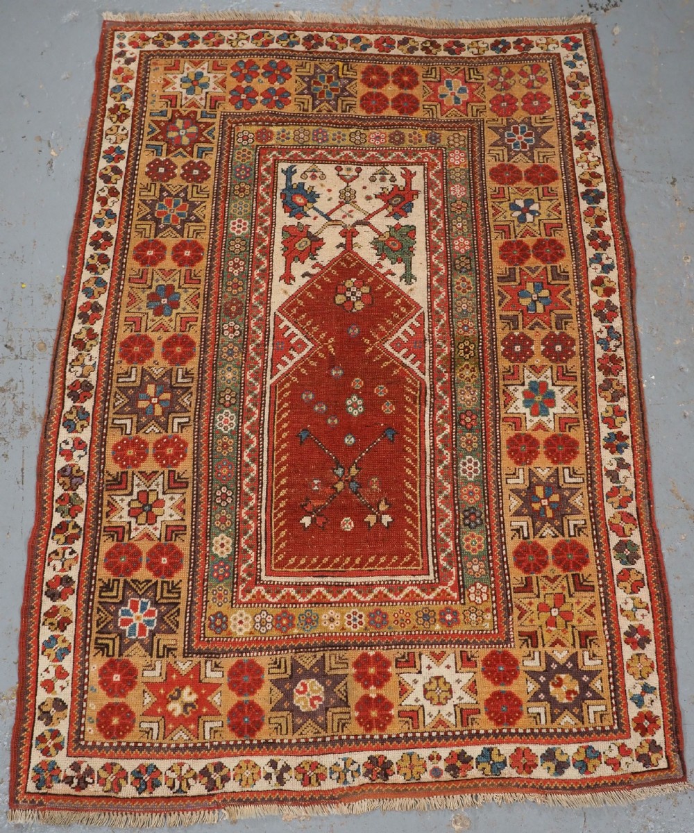 ANTIQUE TURKISH MILAS PRAYER RUG, STAR & ROSETTE BORDER, CIRCA 1800-1825.
