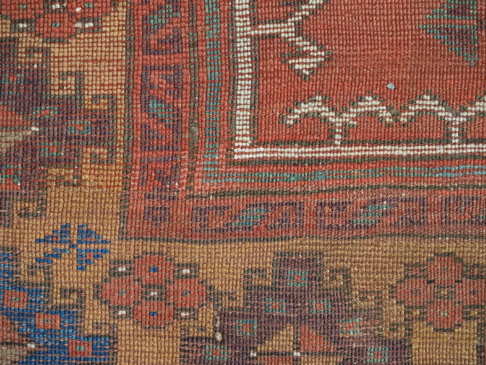 An antique hand-knotted Turkish Konya prayer rug featuring a stepped central red niche surrounded by green, blue, and ochre geometric motifs. View XI