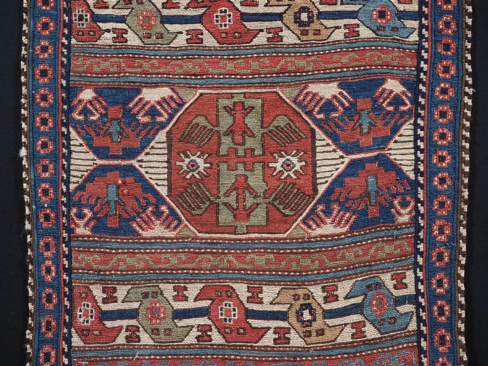 A square antique Shahsevan Soumak woven wool panel featuring central geometric octagonal medallions flanked by bird and dragon motifs in shades of terracotta red, blue, and ivory. View III