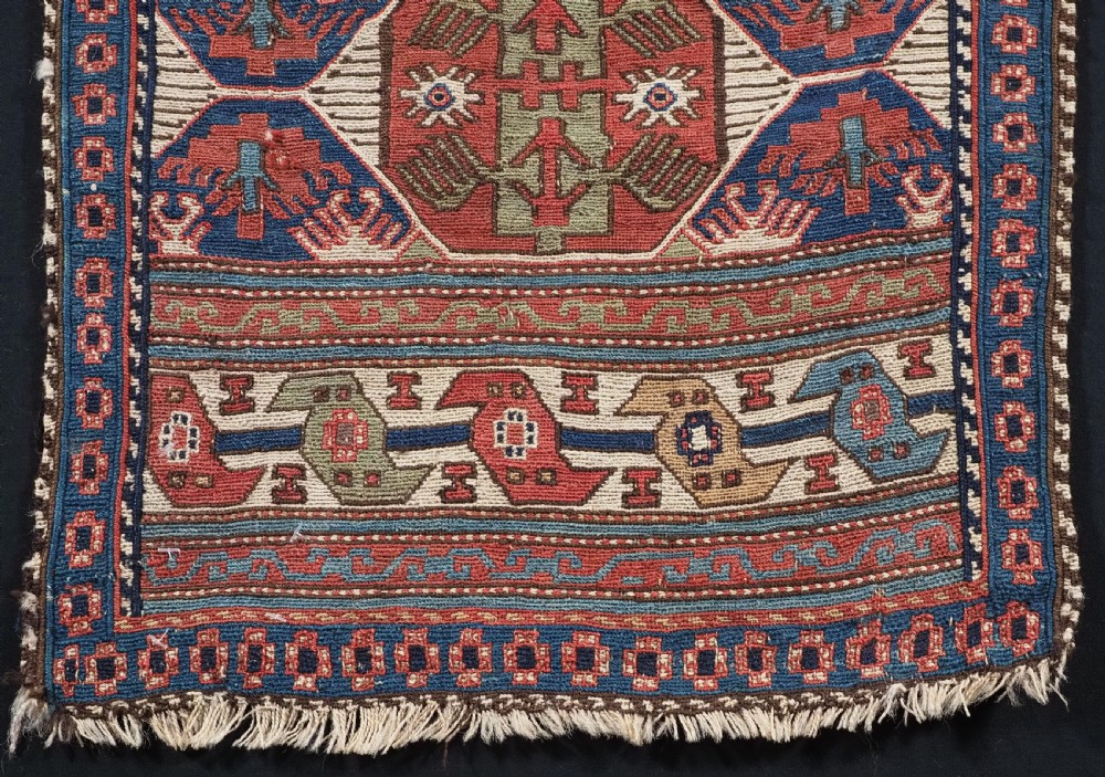A square antique Shahsevan Soumak woven wool panel featuring central geometric octagonal medallions flanked by bird and dragon motifs in shades of terracotta red, blue, and ivory. View IV