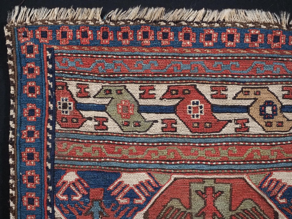 A square antique Shahsevan Soumak woven wool panel featuring central geometric octagonal medallions flanked by bird and dragon motifs in shades of terracotta red, blue, and ivory. View V