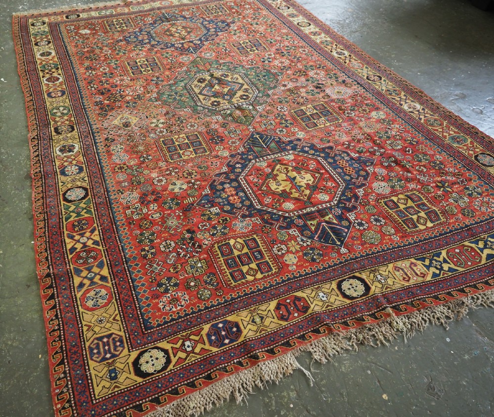 An antique Caucasian flatweave Soumak rug featuring three large geometric medallions on a red field framed by a patterned yellow border. View II