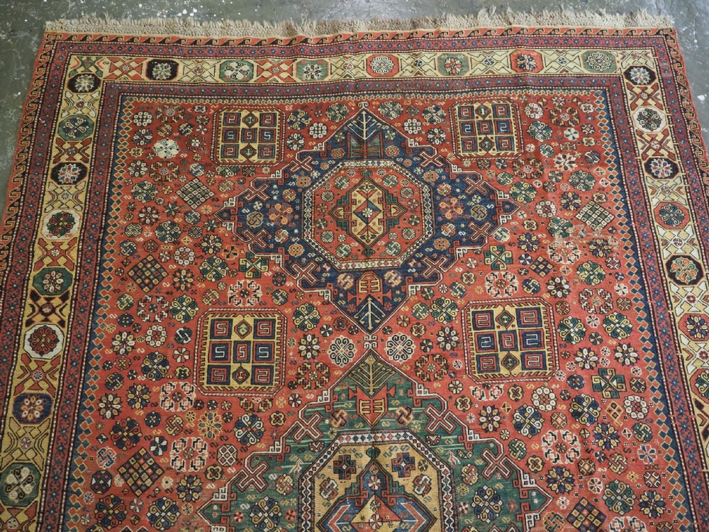 An antique Caucasian flatweave Soumak rug featuring three large geometric medallions on a red field framed by a patterned yellow border. View III