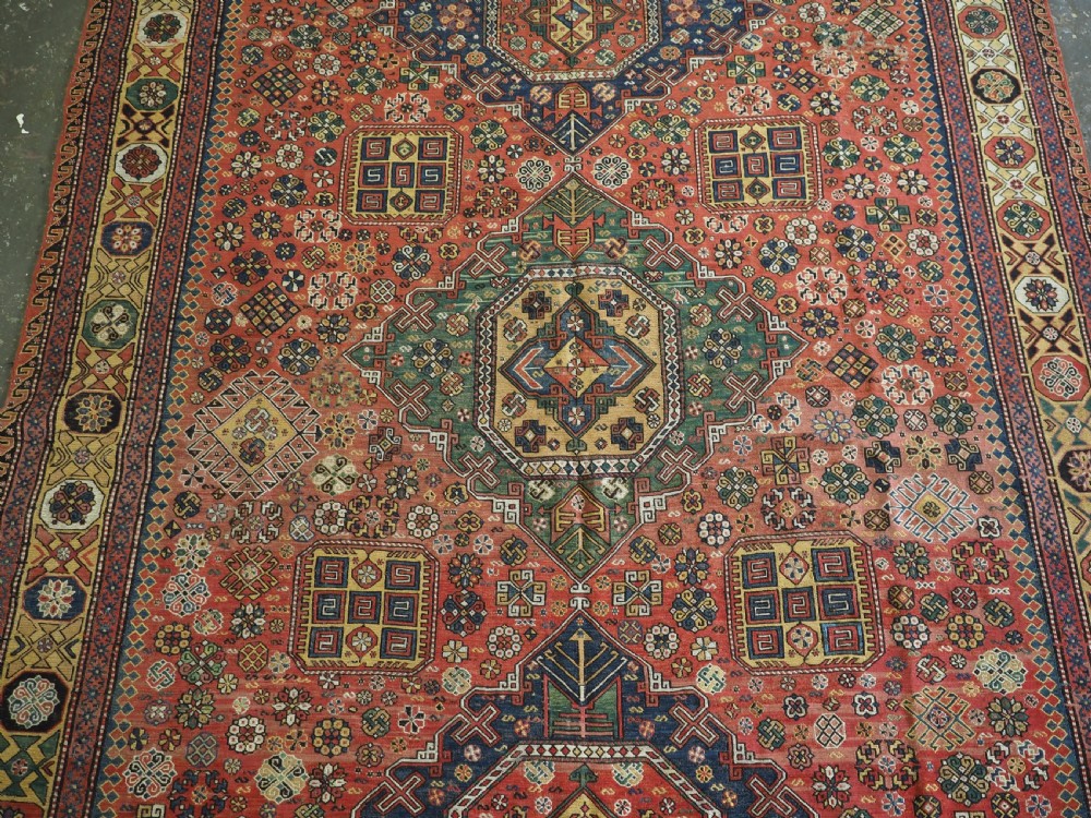 An antique Caucasian flatweave Soumak rug featuring three large geometric medallions on a red field framed by a patterned yellow border. View IV