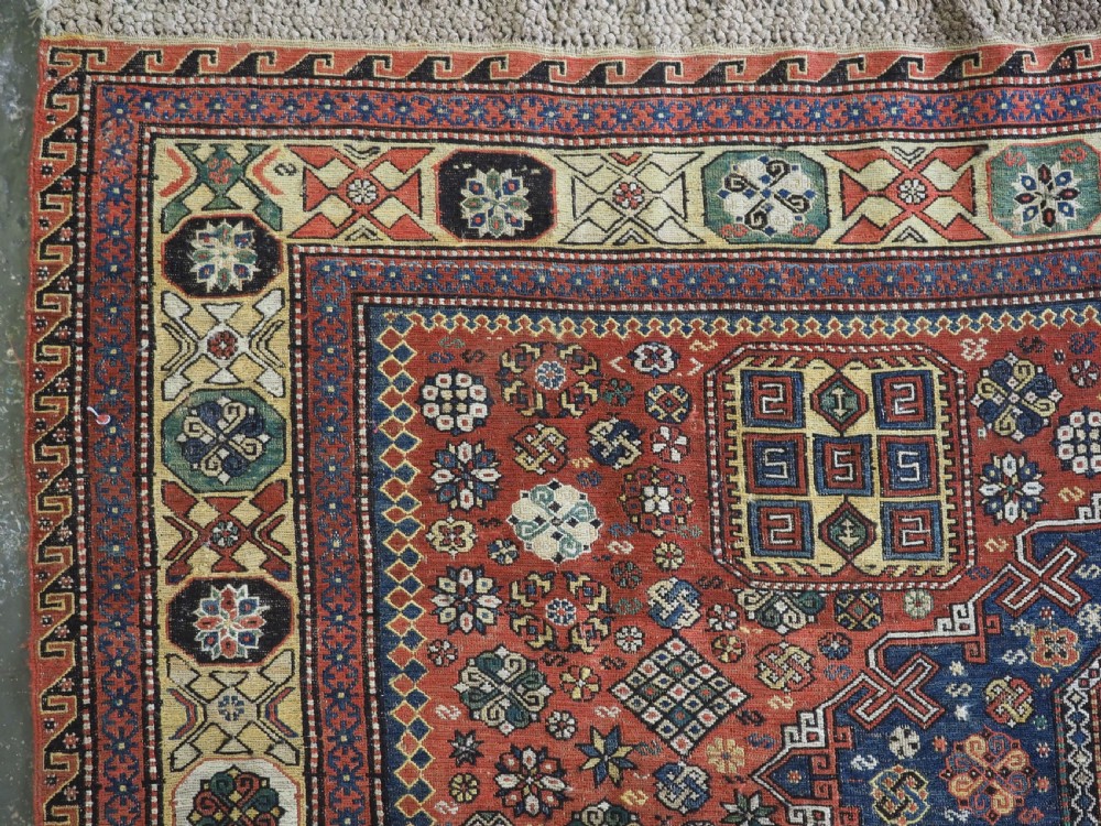 An antique Caucasian flatweave Soumak rug featuring three large geometric medallions on a red field framed by a patterned yellow border. View VI