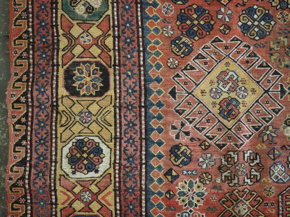 An antique Caucasian flatweave Soumak rug featuring three large geometric medallions on a red field framed by a patterned yellow border. View VII