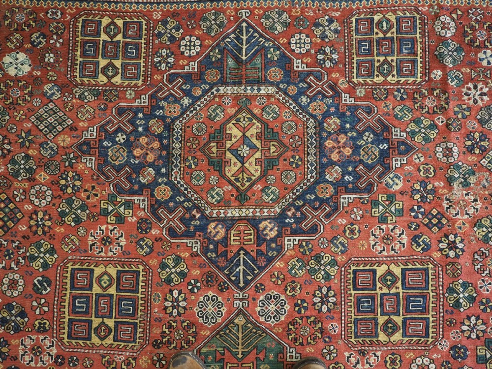An antique Caucasian flatweave Soumak rug featuring three large geometric medallions on a red field framed by a patterned yellow border. View IX