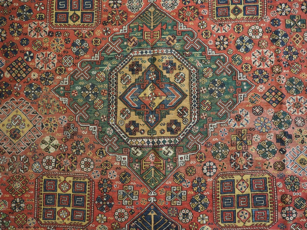 An antique Caucasian flatweave Soumak rug featuring three large geometric medallions on a red field framed by a patterned yellow border. View X