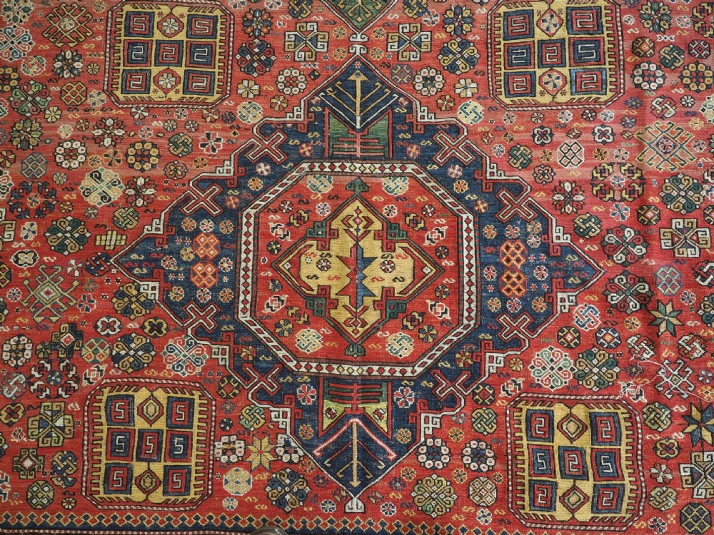 An antique Caucasian flatweave Soumak rug featuring three large geometric medallions on a red field framed by a patterned yellow border. View XI